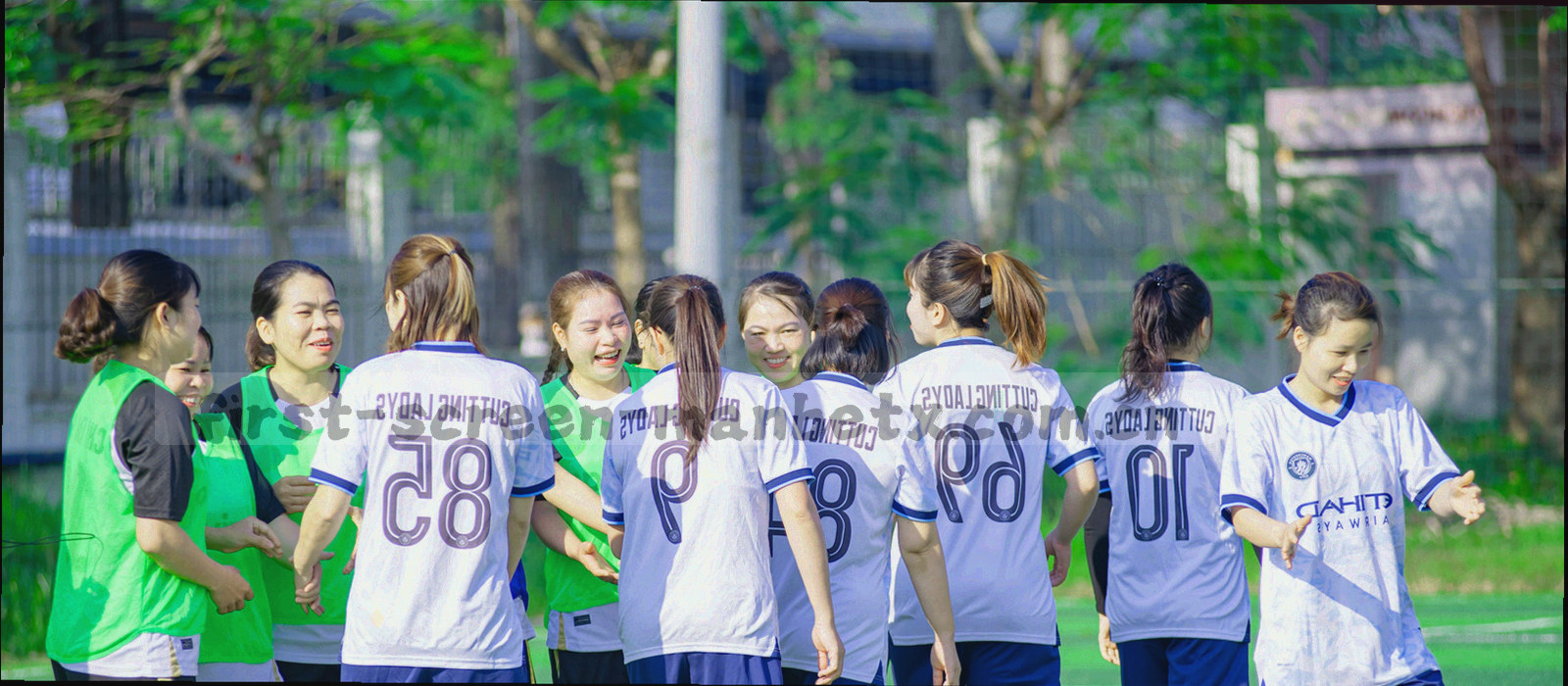 宽屏桌面与键盘的低角度特写，屏幕内容模糊不可辨